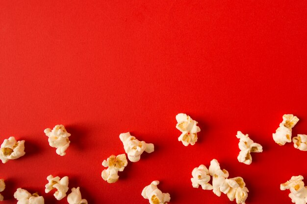 Asortyment płaskie leżał popcorn na czerwonym tle z miejsca kopiowania
