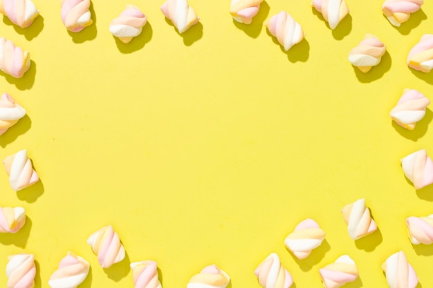 Asortyment widok z góry kolorowych cukierków na żółtym tle z miejsca na kopię