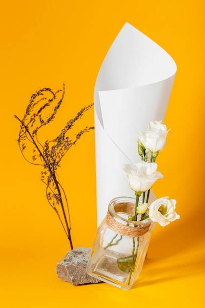 Asortyment z białymi różami w wazonie z papierowym rożkiem