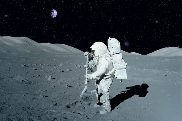 Astronauta w pobliżu łazika księżycowego na księżycu. z lądem na horyzoncie. elementy tego obrazu dostarczyła nasa. w dowolnym celu.