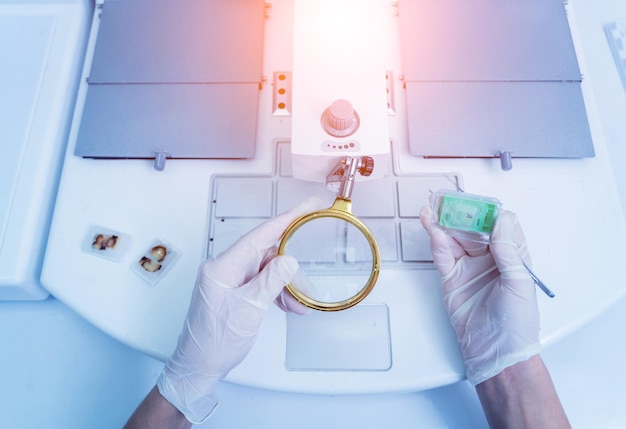 Asystent laboratoryjny pracuje przy maszynie do zatapiania tkankowego dozownika wosku parafinowego
