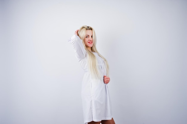Atrakcyjna blondynka lekarka lub pielęgniarka w fartuchu na białym tle