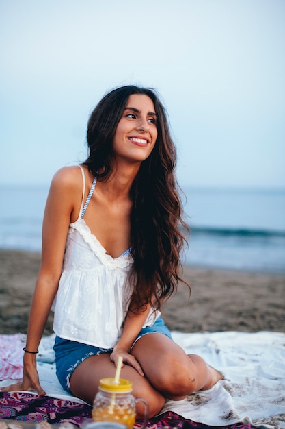 Atrakcyjna kobieta siedzi na plaży