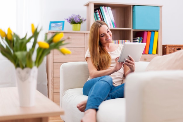 Atrakcyjna kobieta za pomocą cyfrowego tabletu na kanapie