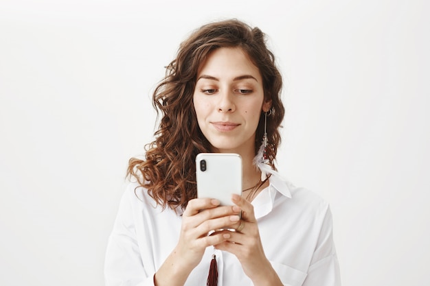 Atrakcyjna kobieta za pomocą telefonu komórkowego, pobierz aplikację