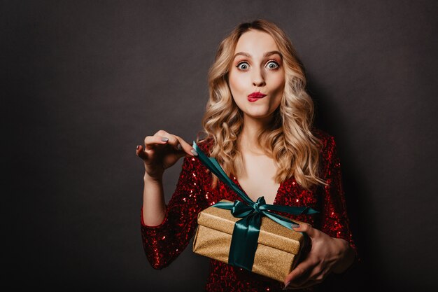 Atrakcyjna młoda kobieta dotyka wstążki na prezent na nowy rok
