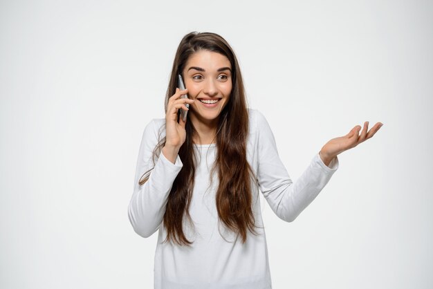 Atrakcyjna uśmiechnięta kobieta opowiada na telefonie komórkowym