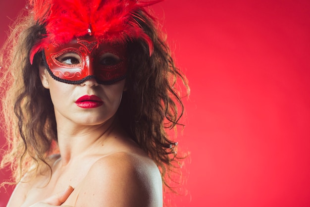 Atrakcyjna zmysłowa kobieta w czerwonej masce