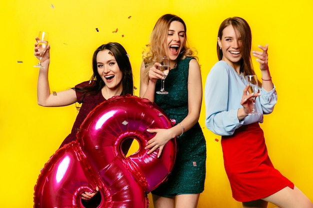 Bezpłatne zdjęcie atrakcyjne uśmiechnięte młode kobiety z wineglasses szampan