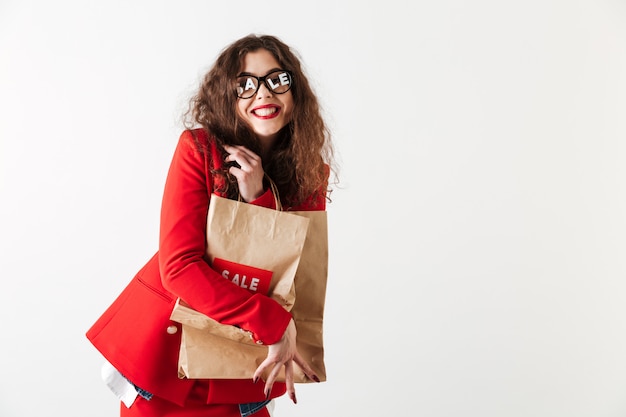 Atrakcyjni sprzedaży kobiety mienia papieru torba na zakupy odizolowywający nad bielem