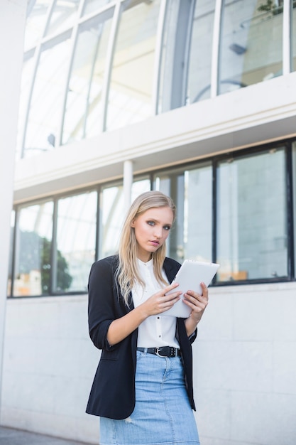 Atrakcyjny bizneswoman trzyma cyfrową pastylkę