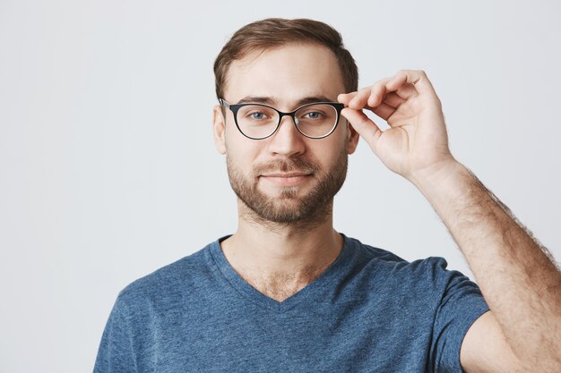 Atrakcyjny brodaty mężczyzna zbiera okulary w sklepie optyka
