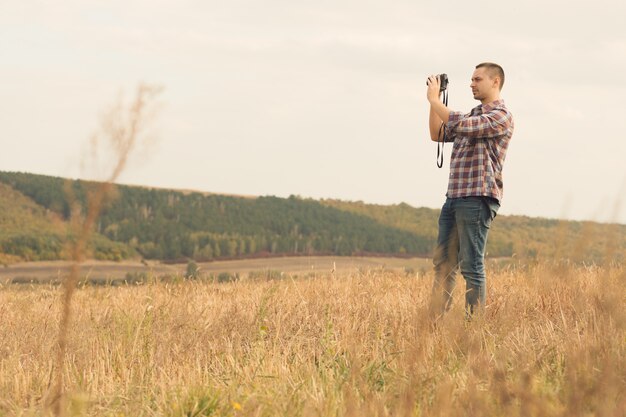 Atrakcyjny męski fotograf outdoors przy zmierzchem
