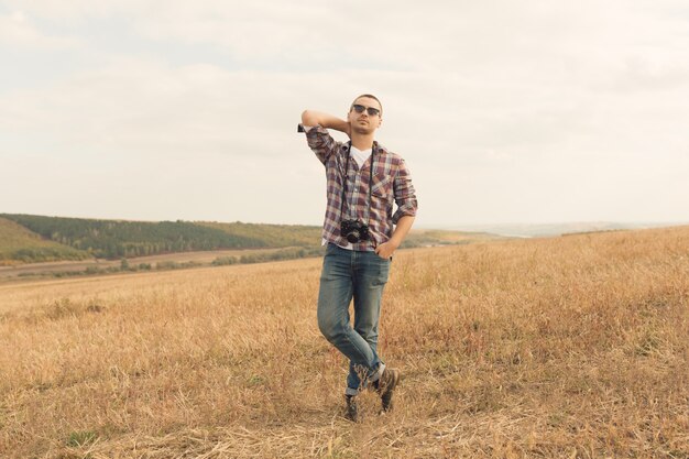 Atrakcyjny męski fotograf outdoors przy zmierzchem