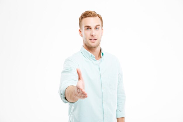 Atrakcyjny Młody Biznesmen Stojący I Podający Rękę Do Uścisku Dłoni Premium Zdjęcia