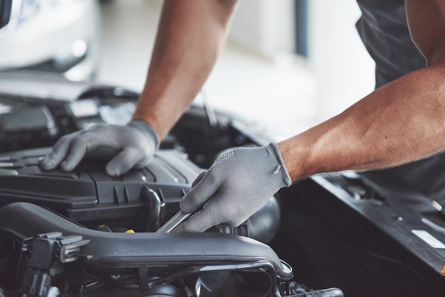 Auto mechanik pracuje w garażu. Serwis naprawczy.