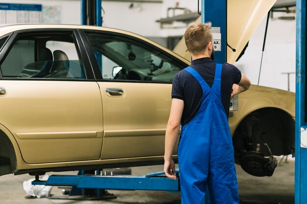 Auto mechanik stoi blisko locklift