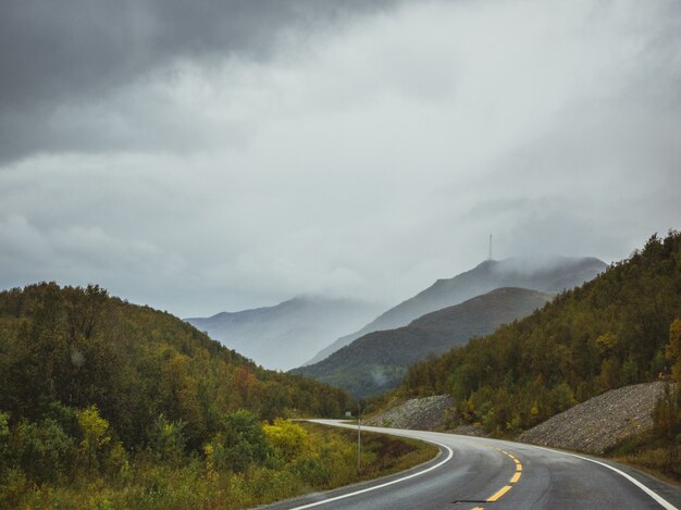 autostrada w pobliżu lasu w górach pod ciemnym pochmurnym niebem