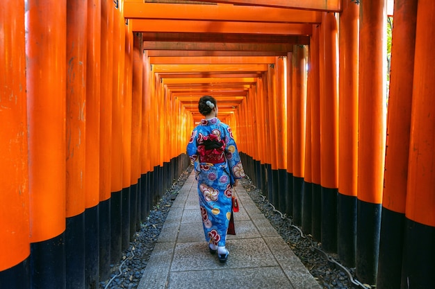 Bezpłatne zdjęcie azjatki w tradycyjnych japońskich kimonach w świątyni fushimi inari w kioto w japonii.