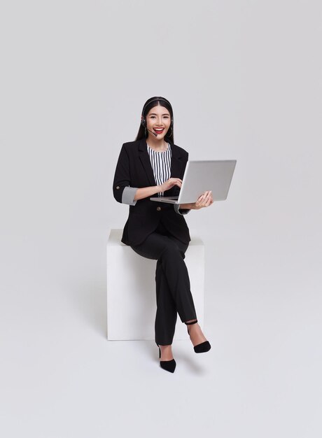 Azjatycka kobieta biznesowa w centrum telefonicznym Witamy kobietę operatorkę w słuchawkach z laptopem