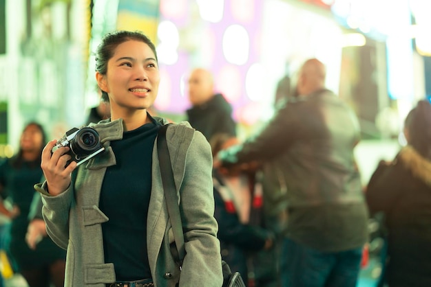 Azjatycka Kobieta Podróżniczka Uśmiech Szczęście Ręka Trzyma Aparat Bez Lustra Ciesz Się Nocnym życiem Tourost Z Jasnym Bokeh I Tłumem Ludzi Rozmycie Tła W Sezonie Zimowym