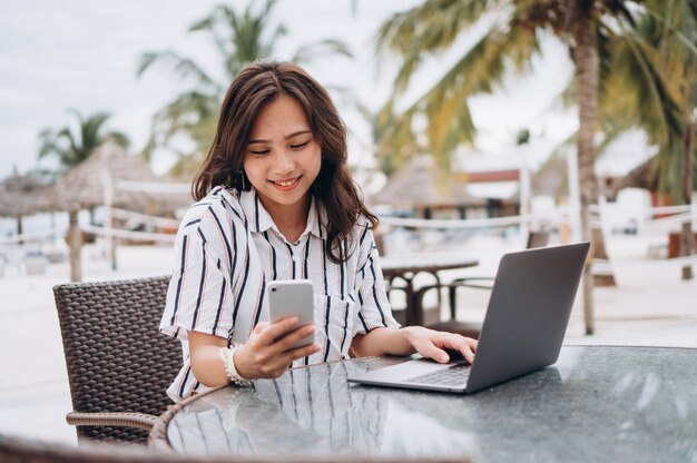 Azjatycka kobieta pracuje na laptopie na wakacje