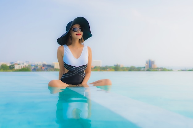 Azjatycka kobieta relaksuje w pływackim basenie