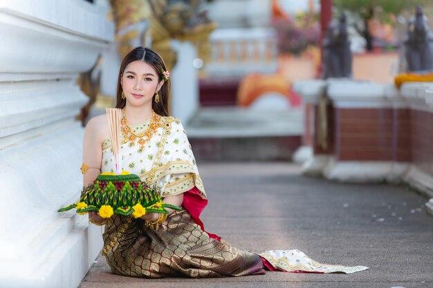 Azjatycka kobieta w tradycyjnym stroju tajskim posiadają festiwal kratong Loy krathong