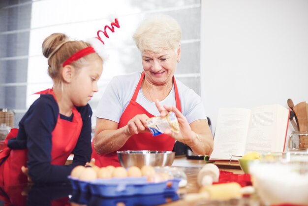 Babcia uczy swoją wnuczkę robić domowe słodycze