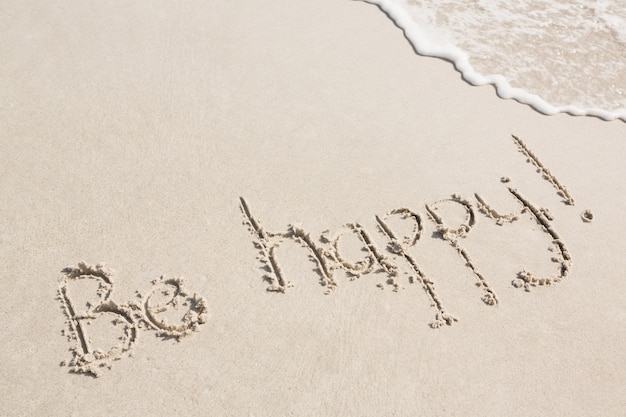 Bezpłatne zdjęcie bądź szczęśliwa napisane na piasku