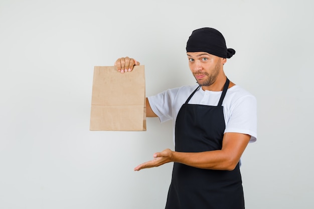 Baker man pokazując papierową torbę w t-shirt