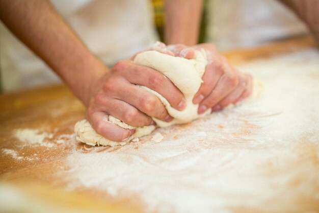 Bakers ręce wyrabiania ciasta na licznik