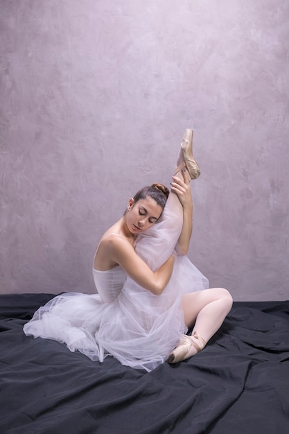 Bezpłatne zdjęcie baleriny widok z boku trzyma nogę