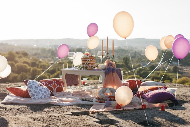 Balony lewitują w powietrzu nad białym stołem ze świecami