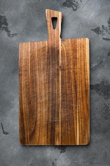 Bambusowa deska do krojenia w kuchni ustawiona na pustą dla miejsca kopiowania tekstu lub jedzenia, widok z góry płasko leżący, na szarym tle kamiennego stołu