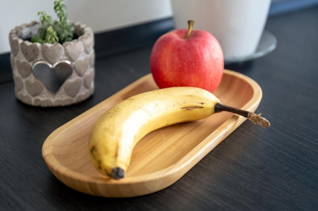 Bezpłatne zdjęcie banan i jabłko na kuchennym stole