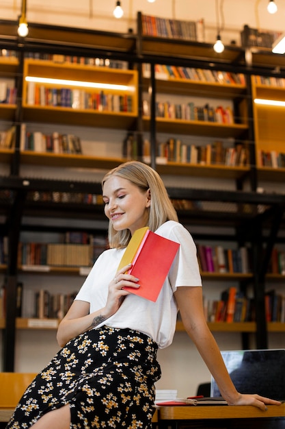 Bezpłatne zdjęcie bardzo młoda kobieta pozuje w bibliotece