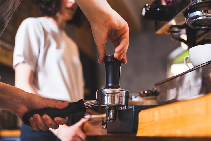 Bezpłatny plik Zdjęcie barista ręka przygotowuje cappuccino w kawiarni