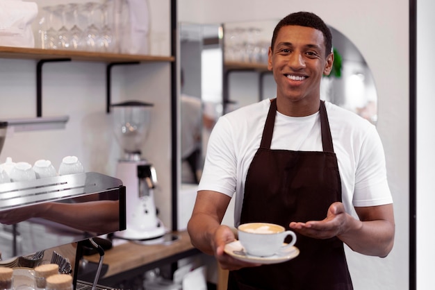 Barista średniego strzału z filiżanką kawy