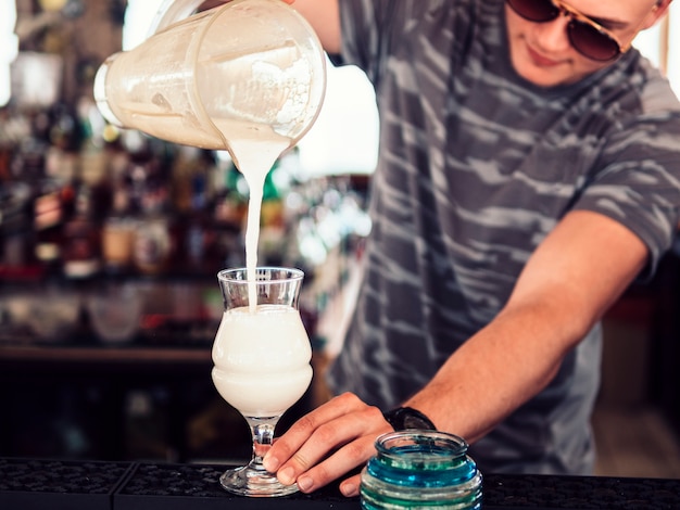 Barman leje koktajl mleczny w szkle