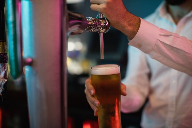 Barman napełniający piwo z pompy barowej