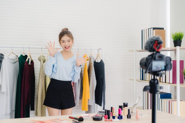 Beauty blogger przedstawia kosmetyki kosmetyczne siedząc w przedniej kamery do nagrywania wideo