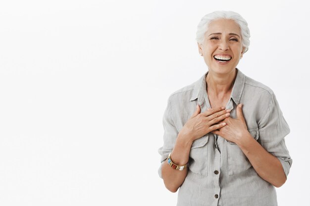 Beztroski szczęśliwa starsza kobieta z siwymi włosami, śmiejąca się i uśmiechnięta