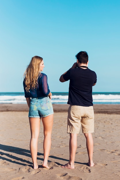 Beztwarzowa para bierze obrazki na plaży
