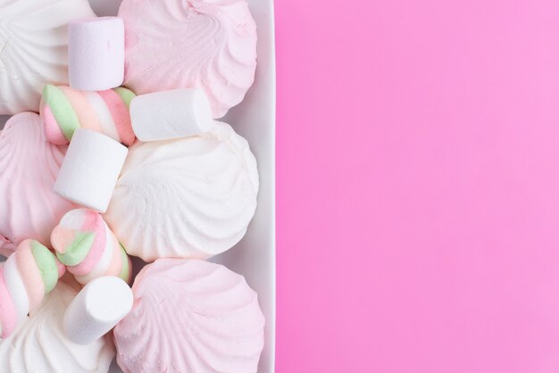 Bezy i pianki marshmallows z góry są słodkie i pyszne na różowym, słodkim biszkoptowym słodkim cukrze