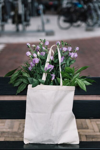 Biała bawełniana torebka z pięknymi purpurowymi eustoma kwiatami