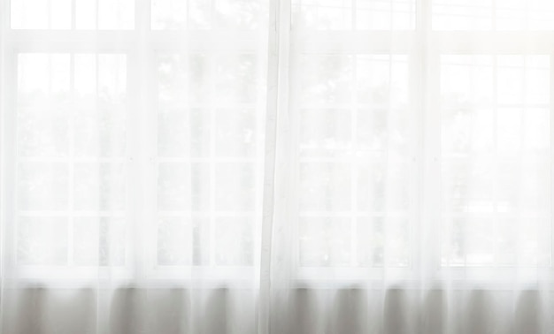 Biała falująca zasłona z przezroczystą zasłoną na oknie na tle deseniowym