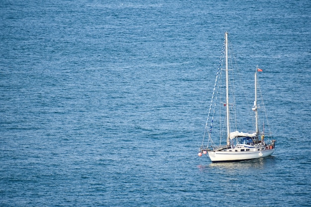 Bezpłatne zdjęcie biała łódź pływająca po spokojnym morzu w ciągu dnia