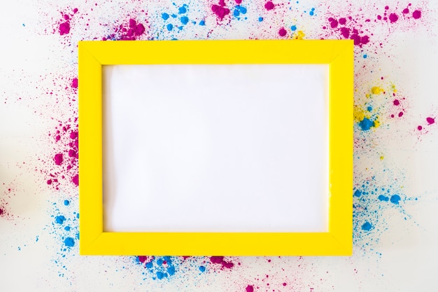 Biała pusta rama z żółtą obwódką na holi koloru proszku nad białym tłem