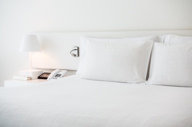 Białe łóżko z białymi poduszkami